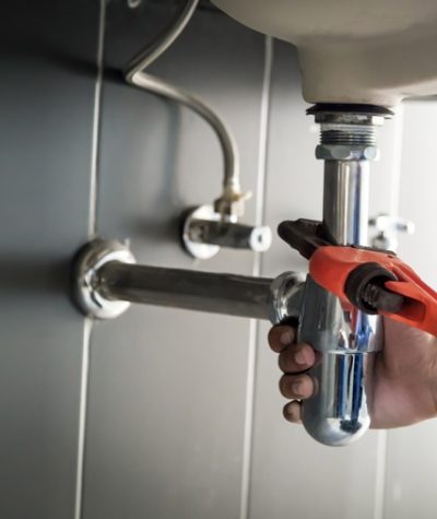 Plumber,Uses,Wrench,To,Repair,Water,Pipe,Under,Sink,There